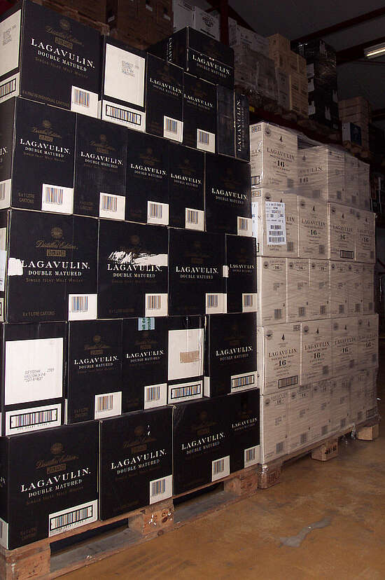 left pallet is filled with the dark cases of Lagavulin distillers edition, right white cases of Lagavulin 16